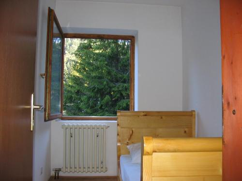 a bedroom with a bed with a window and a radiator at Villa Kostic Kopaonik in Kopaonik