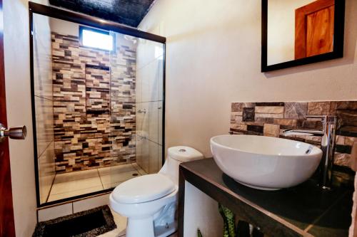 La salle de bains est pourvue d'un lavabo, de toilettes et d'une douche. dans l'établissement Casa Monarca - Monteverde, à Monteverde Costa Rica