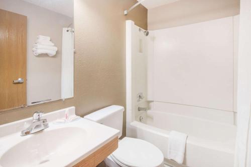 a bathroom with a white toilet and a sink at Super 8 by Wyndham Jamestown in Jamestown