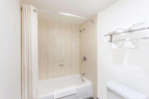 a white bathroom with a tub and a toilet at Super 8 by Wyndham El Cajon San Diego in El Cajon