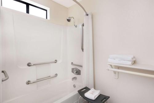 La salle de bains est pourvue d'une douche et d'un lavabo. dans l'établissement Super 8 by Wyndham Corning, à Corning