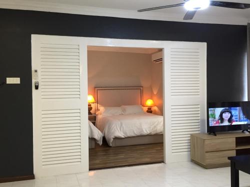 1 dormitorio con 1 cama y TV de pantalla plana en D’Savoy @ Famosa by SH en Melaka