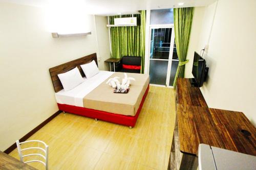 a hotel room with a bed and a television at AC Sport Village in Bangkok