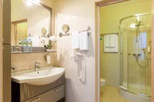 uma casa de banho com um lavatório e um chuveiro em Triumph Hotel em Obninsk