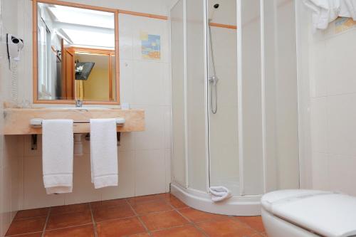 a bathroom with a shower and a sink and a toilet at Hostal Jayma in Salobreña