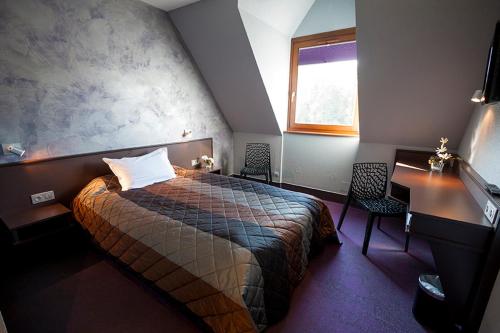 a hotel room with a bed and a window at Hôtel Restaurant Les Alizés in Lipsheim