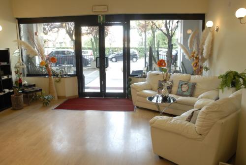 a living room with two couches and a glass door at Hotel Provenza in Ventimiglia