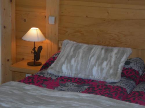 a bedroom with a bed with a pillow and a lamp at Le Cordonant in Cordon