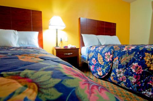 a hotel room with two beds and a lamp at Passport Inn and Suites - Middletown in Middletown
