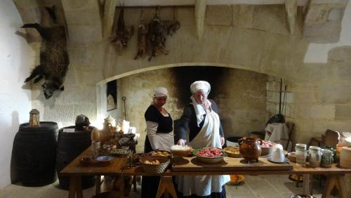 Deux femmes debout dans une cuisine avec de la nourriture sur une table dans l'établissement CHAMBRE du SABOTIER - Studio troglodytique - A 100 m Baignade en rivière - Location de Canoë - Circuits cyclo - Aire de pique-nique - 3 restaurants, à Castelnaud-la-Chapelle