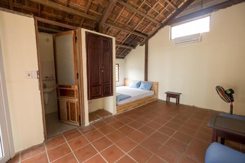 a bedroom with a bed and an open door at Tam Thanh Natural Beach Resort in Tam Kỳ