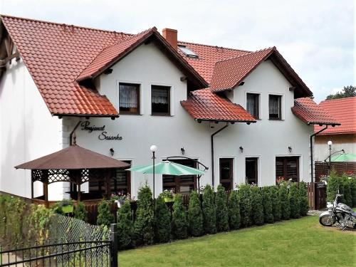 Biały dom z czerwonym dachem w obiekcie Pensjonat Sasanka - Jarosławiec w mieście Jarosławiec
