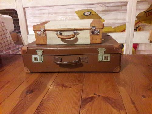 two suitcases stacked on top of each other on a wooden floor at B&B Le Bonimenteur in Charleroi