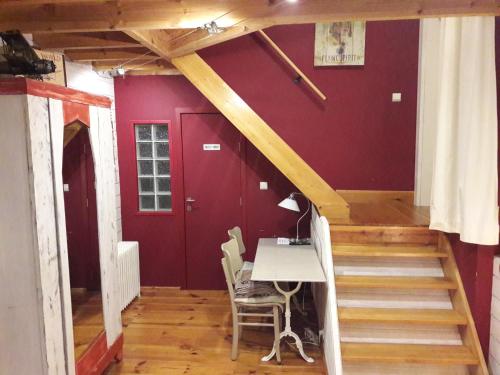 a staircase in a room with a table and a red wall at B&B Le Bonimenteur in Charleroi