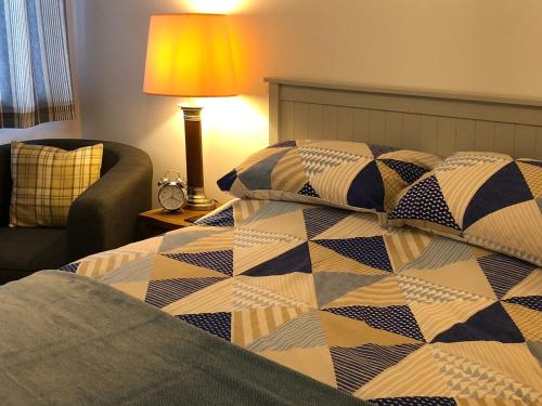 um quarto com uma cama com uma colcha em Coast Apartment em Sidmouth