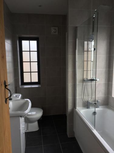 a bathroom with a toilet and a tub and a sink at Bishop Percys House in Bridgnorth
