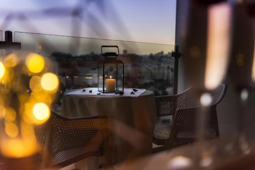 a candle sitting on a table with chairs at Ambassador Hotel in Jerusalem