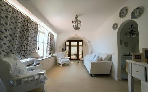 a living room with white chairs and a table at Villa Gaia - Elegant Holiday Home in a sun and sea setting in Avola