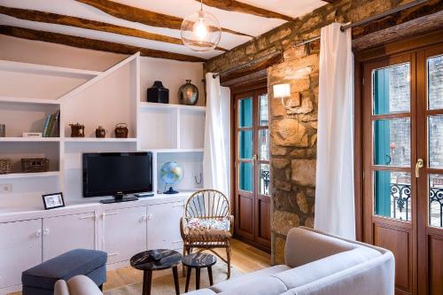 a living room with a couch and a tv at Apartamento Carlos V in Hondarribia
