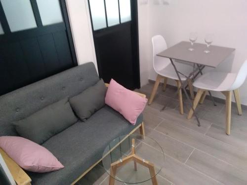 a living room with a couch and a table at Chambre d'Hôtes Les Macarons de Tata in Sainte-Eulalie