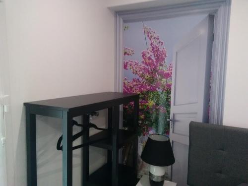 a black table in a room with a vase of flowers at Chambre d'Hôtes Les Macarons de Tata in Sainte-Eulalie
