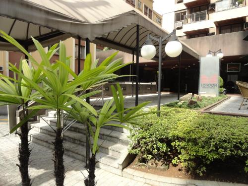 a couple of palm trees in front of a building at London Class Hotéis in Sao Paulo