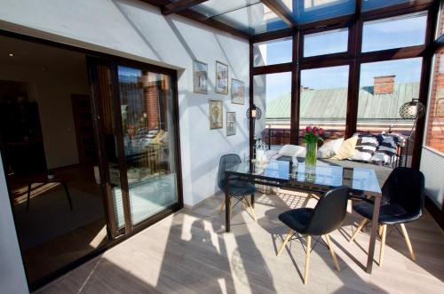 a dining room with a glass table and chairs at 7 Koron - Exclusive Apartments in Kraków