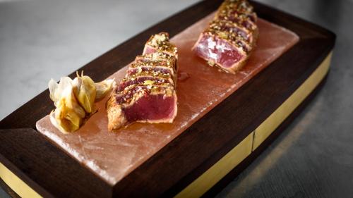 a cutting board with meat and vegetables on it at Nobis Hotel Stockholm, a Member of Design Hotels in Stockholm