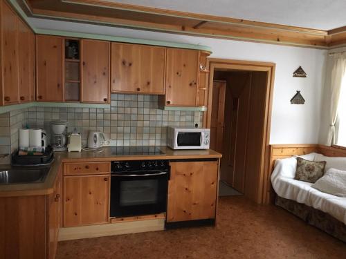 a kitchen with wooden cabinets and a microwave at Stadlbauergütl in Leogang