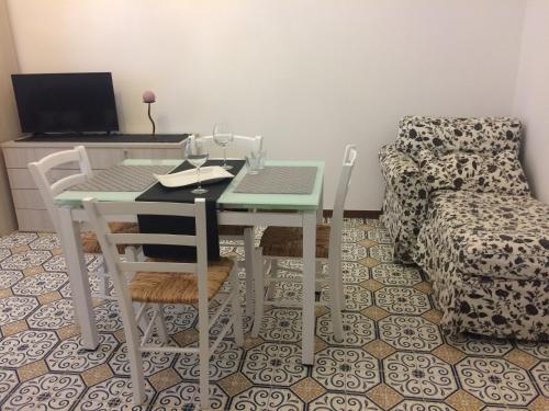 a room with a table and chairs and a couch at Casa gli Scogli in Chiavari