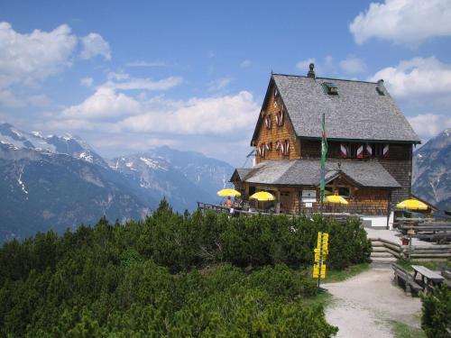 a large wooden building with yellow umbrellas on a mountain at Stadlbauergütl in Leogang