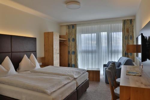 a hotel room with a bed and a desk at Gasthof Alpenblick in Amstetten