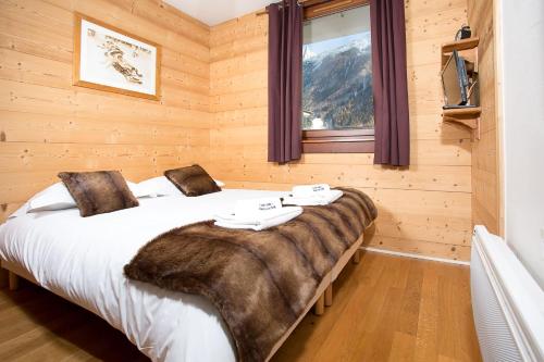 - une chambre avec un grand lit et une couverture dans l'établissement Le Paradis ski apartment - Chamonix All Year, à Chamonix-Mont-Blanc