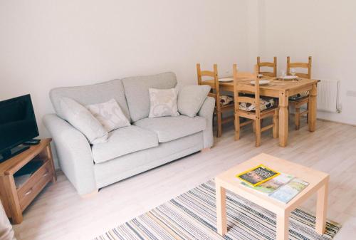 a living room with a couch and a table at Tennyson Cottage in Freshwater