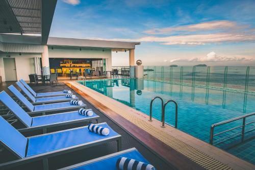 a hotel swimming pool with a view of the ocean at Mercure Kota Kinabalu City Centre in Kota Kinabalu