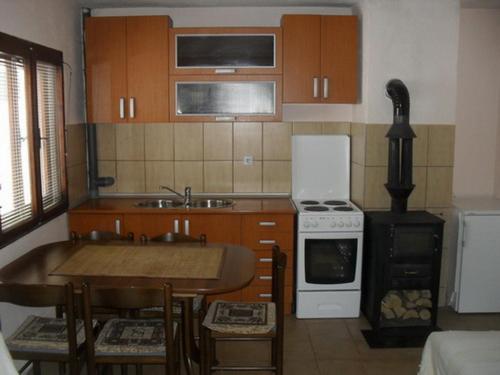 a small kitchen with a table and a stove at Golubović Apartments in Žabljak