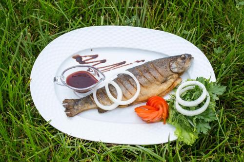 a plate of fish and vegetables on the grass at Gabala Yengice Thermal Resort Hotel in Yengica