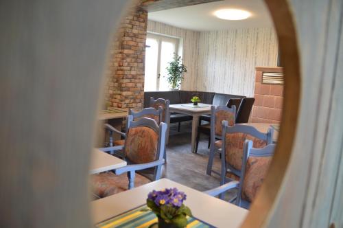 a dining room with a table and chairs and a mirror at Ostsee Radlerpension Peitz in Peitz