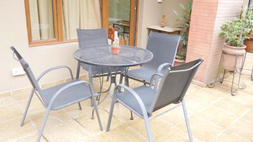 a patio table with chairs and a table with a cat on it at Green Terrace in Tbilisi City