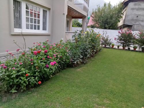 a garden of flowers in front of a house at Snow Leopard Lodge in Srinagar
