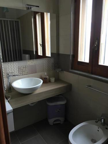 a bathroom with a sink and a toilet and a mirror at Casa Albergo La Terza Stella in Agira