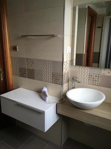 a bathroom with a white sink and a mirror at Casa Albergo La Terza Stella in Agira