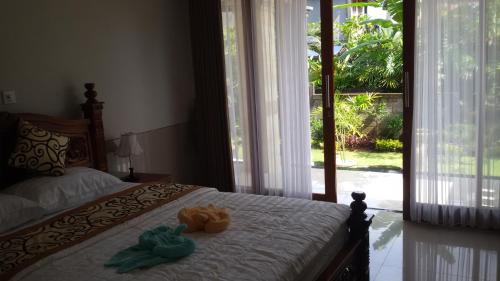 a bedroom with a bed with two stuffed animals on it at Murdhasari in Ubud