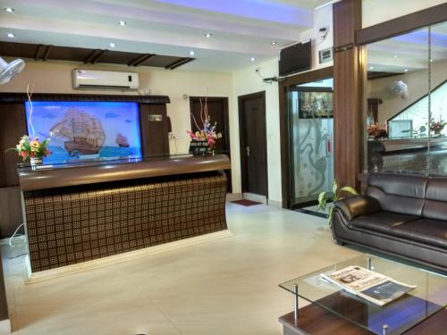迪布鲁加尔Hotel Raj Palace的配有沙发和平板电视的客厅
