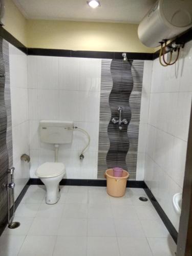 a bathroom with a toilet and a bucket at Hotel Raj Palace in Dibrugarh