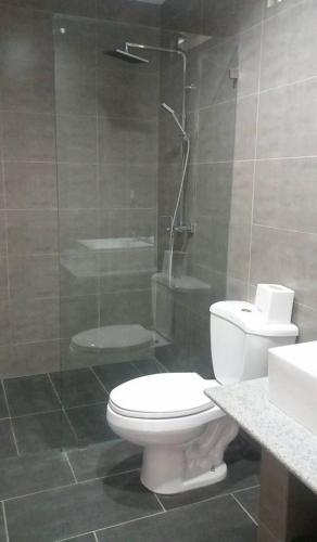 a bathroom with a white toilet and a shower at panglao moravian apartments in Panglao Island