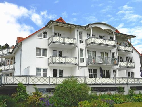 um grande edifício branco com varandas em Villa Vilmblick - Wohnung 07 mit Terrasse und Boddenblick em Lauterbach