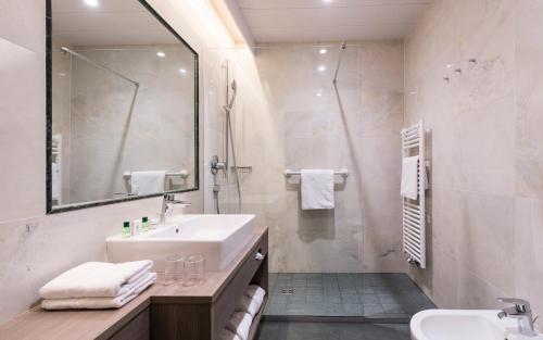 a bathroom with a sink and a shower at Hotel Grüner Baum in Bressanone