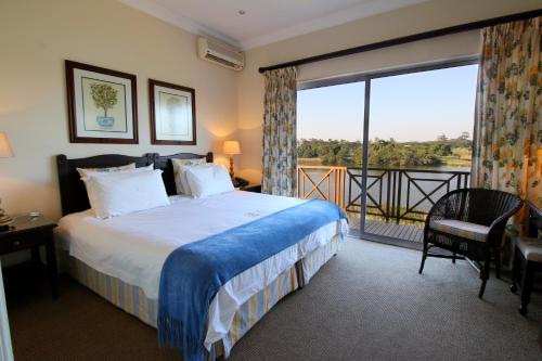 a hotel room with a bed and a large window at Kingfisher Lodge in Mount Edgecombe