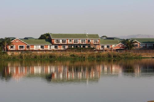a large house sitting next to a body of water at Kingfisher Lodge in Mount Edgecombe